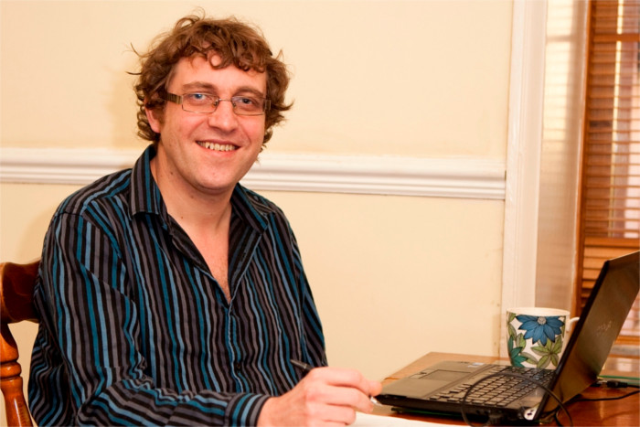 Picture of Paul holding a pen working at his desk with a laptop and calculator - Services Paul provides,  General consultancy, system reviews, risk review, management accounts, Statutory Accounts Preparation, Independent examinations, Preparation for audit, Training, Taxation including VAT, prepare and file corporation tax for small companies and CICs - Paul Cowham Accountancy - Manchester based accountant specialising in the charity and social enterprise sectors